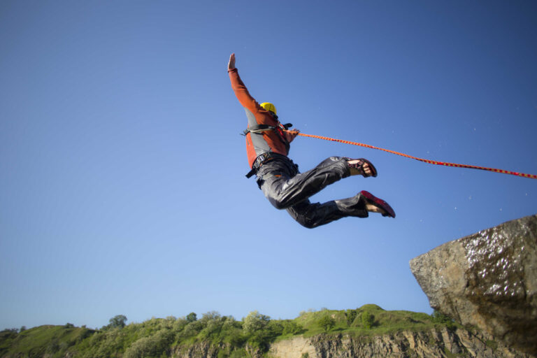 Homme attaché se jetant en bas d'une falaise