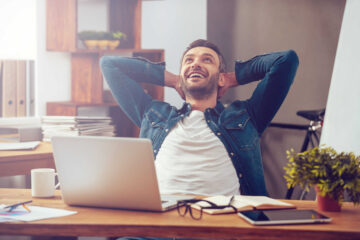 Homme heureux devant son ordinateur portable au bureau