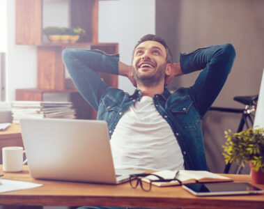 Homme heureux devant son ordinateur portable au bureau