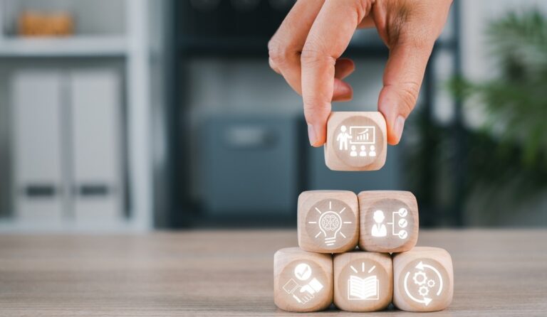 Blocs de bois avec icônes symbolisant le développement des compétences en entreprise