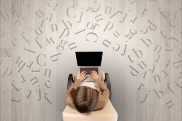 Lettres avec une femme utilisant un ordinateur portable sur une chaise